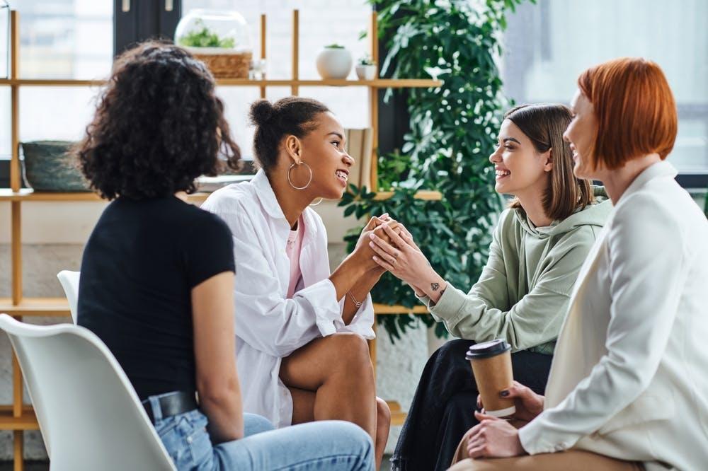 A group of women talking to each other seated in a circle 