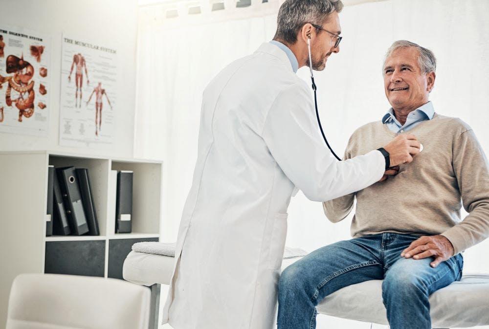 Consultation, man and doctor in checkup with stethoscope, help and advice for healthcare in office. 