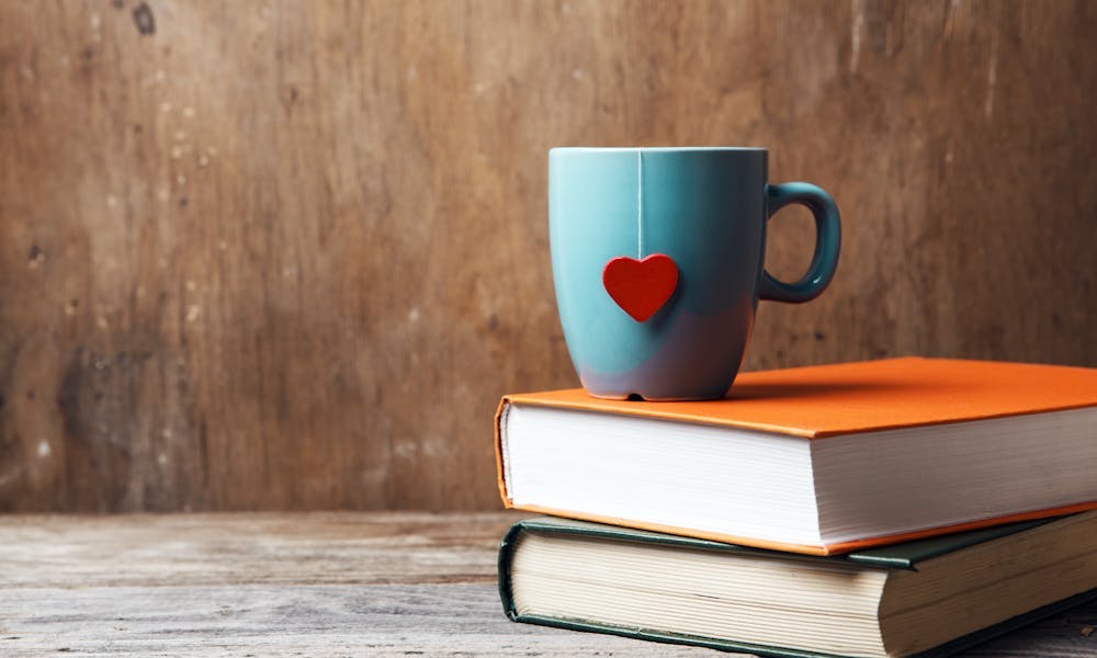 A teacup sitting on top of two books